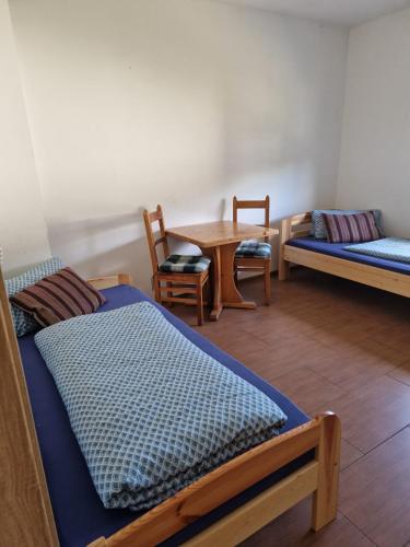a room with two beds and a table and chairs at FeWo NAHE Berlin für bis zu 8 Monteure in Mittenwalde