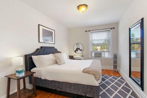 a bedroom with a large white bed and a window at Ideal, Spacious & Furnished 1BR Apartment - Cullom C2 in Chicago
