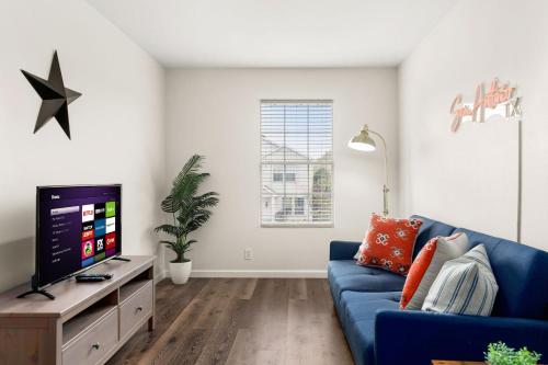 a living room with a blue couch and a tv at Private Heated Pool & Hot Tub, 4BR Gameroom in San Antonio
