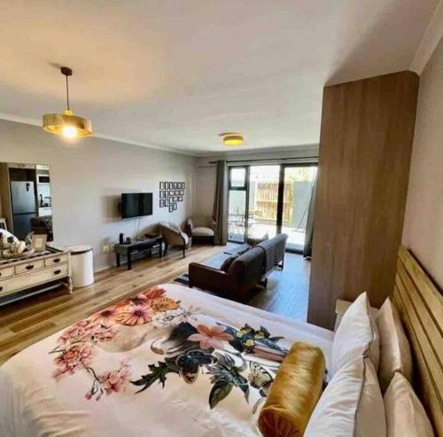 Un dormitorio con una cama grande y una sala de estar. en Blouberg Studio, en Ciudad del Cabo