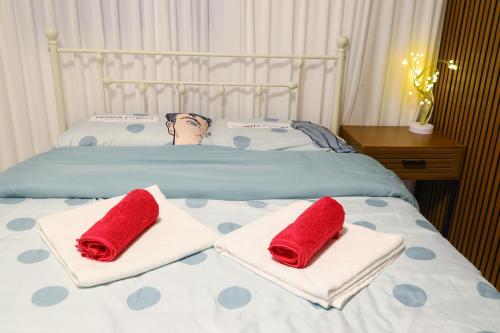 Una cama con dos toallas rojas encima. en דירת אירוח vip רק 5 דקות נסיעה מהים חלום של מקום, en Ashkelon