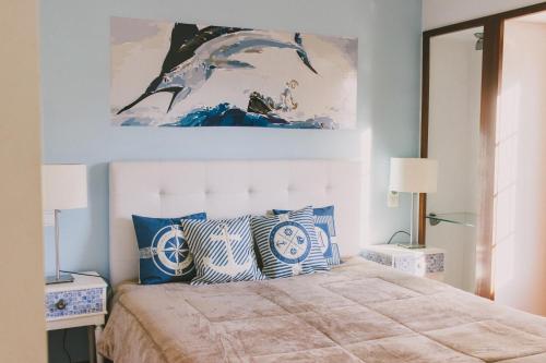 Schlafzimmer mit einem Bett mit blauen und weißen Kissen in der Unterkunft Casas de Campo Villa D'Almeida in Travancinha