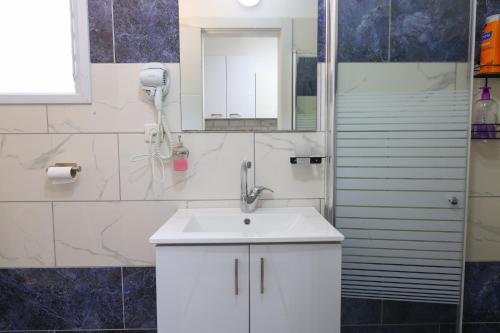 Un baño con un lavabo blanco y un espejo. en דירת אירוח vip רק 5 דקות נסיעה מהים חלום של מקום, en Ashkelon