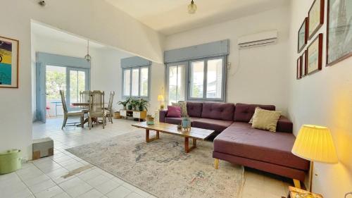 - un salon avec un canapé violet et une table dans l'établissement Beautiful apartment - Dizengoff square, à Tel Aviv