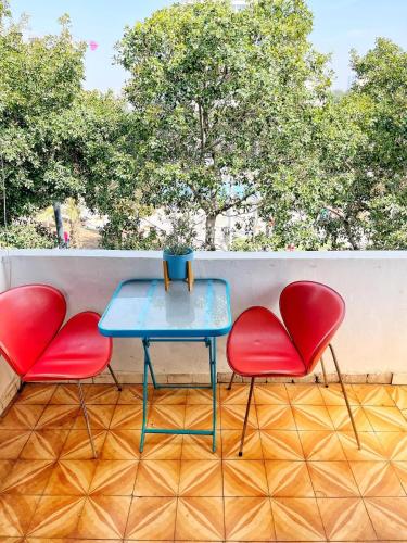 - deux chaises rouges et une table bleue sur un balcon dans l'établissement Beautiful apartment - Dizengoff square, à Tel Aviv