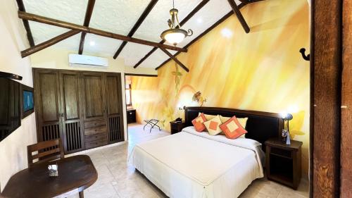 ein Schlafzimmer mit einem Bett, einem Tisch und einem Stuhl in der Unterkunft Tequendama Hotel Campestre Villavicencio in Villavicencio