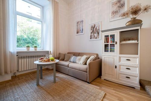 uma sala de estar com um sofá e uma mesa em Old Town WAWEL II Premium Apartment – 52m2 em Cracóvia