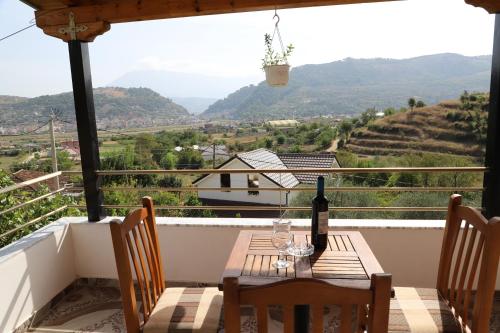 a table with a bottle of wine on a balcony at Villa Rexho in Berat
