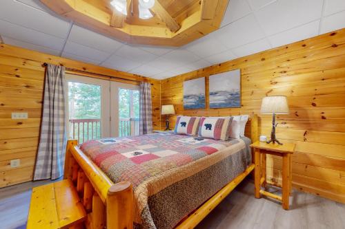 een slaapkamer met een bed in een blokhut bij Moose Tracks Lodge in Pigeon Forge