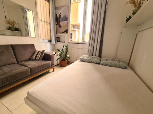 - un salon avec un lit et un canapé dans l'établissement Apto Versátil Praia de Botafogo, à Rio de Janeiro