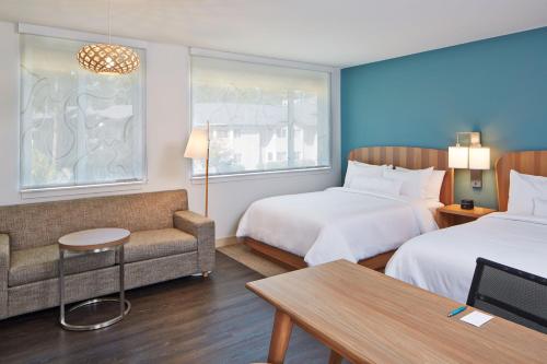 アルバカーキにあるElement Albuquerque Uptownのベッド2台とソファが備わるホテルルームです。