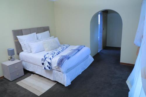 um quarto com uma cama com um edredão azul e branco em 540 BIRSTON em Pretoria