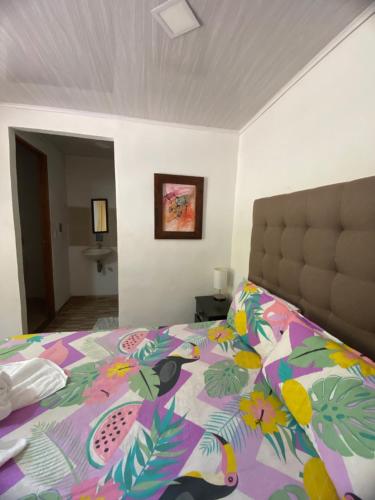 a bedroom with a bed with a colorful comforter at Oak Tree house in Guatapé