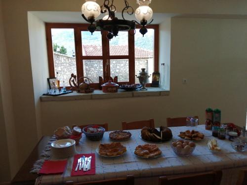 un tavolo con cibo sopra in una stanza con finestra di Ξενώνας Ερυκίνη a Dhímitra