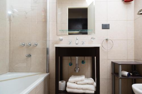 ein Badezimmer mit einem Waschbecken und einer Dusche mit Handtüchern in der Unterkunft Alojamientos Bariloche in San Carlos de Bariloche