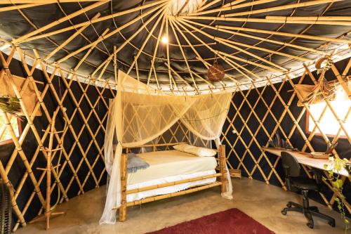 - une chambre avec un lit dans une tente dans l'établissement Corumbau Cura, à Prado
