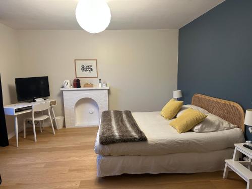 1 dormitorio con 1 cama, escritorio y TV en La Pierre Percée en Vertou