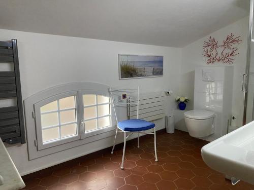 baño con aseo y taburete azul en Villa les Palmiers en Calcatoggio