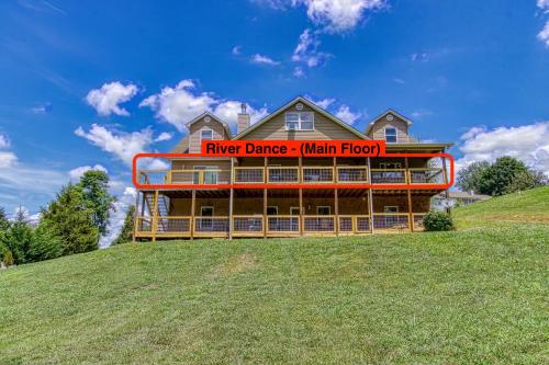 a house on top of a grassy hill at River Dance by HoneyBearCabins in Sevierville