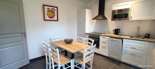 een keuken met een houten tafel en witte kasten bij Gîte VILLA ESPERANZA (2-6 personnes) in Valençay