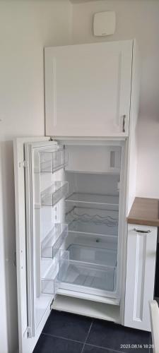 an empty white refrigerator with its door open at Gîte climatisé VILLA ESPERANZA à Valençay 2 à 5 p proche zoo de Beauval et châteaux Pour touristes et travailleurs in Valençay