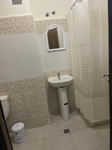 a bathroom with a sink and a toilet and a mirror at Jardin hay chrifia in Marrakech