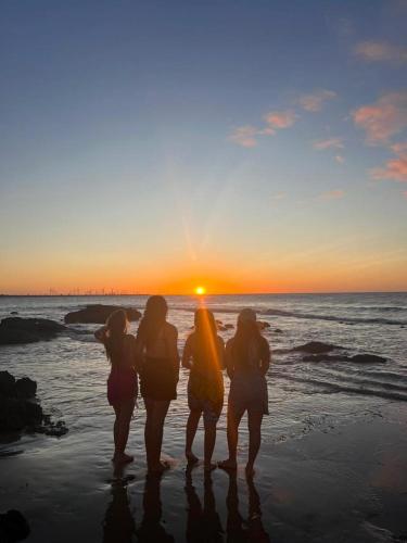 a group of women standing on the beach at sunset at Espetacular Casa de Charme em São Miguel do Gostoso - Salou in São Miguel do Gostoso