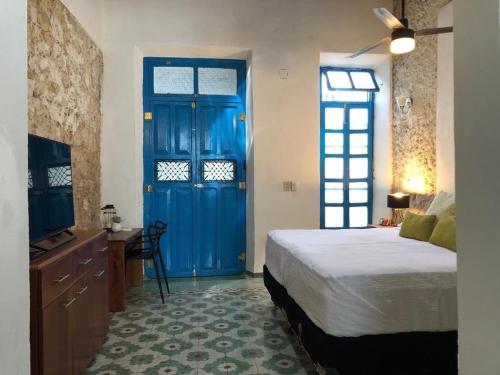 a bedroom with a bed and a blue door at Casita de la 12 5 min a centro Campeche ideal para 2 ó 3 personas Cocina con estufa de inducción, microondas y refrigerador in Campeche