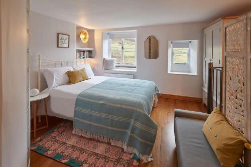 une chambre avec un grand lit et un canapé dans l'établissement Stunning 3 bed Yorkshire Dales cottage, à Appletreewick