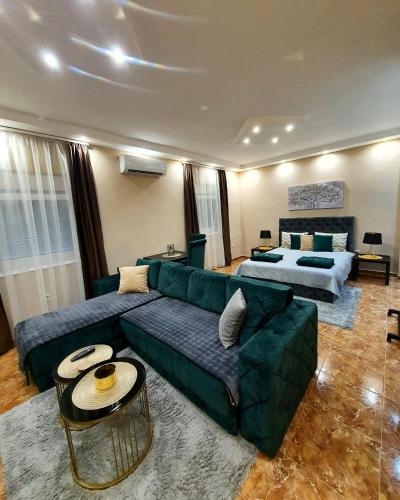a living room with a green couch and a bed at Emerald Apartment Belgrade in Senjak (historical)