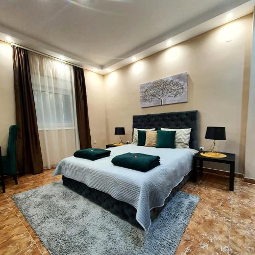 a bedroom with a large bed with two green pillows at Emerald Apartment Belgrade in Senjak (historical)