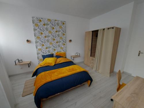 a bedroom with a bed with a yellow blanket at Appart' DuChatelain lumineux, vue sur château in Montbéliard