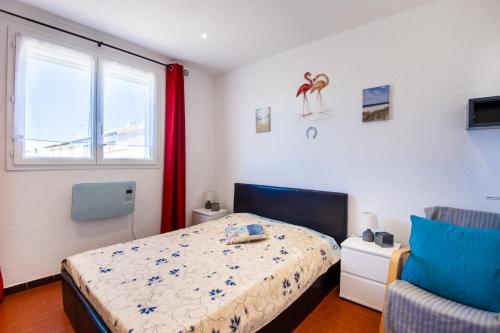 a bedroom with a bed and a window at Le Tau in Saintes-Maries-de-la-Mer