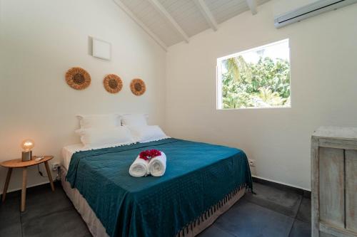 1 dormitorio con 1 cama con 2 toallas en La Petite Caravelle Guadeloupe, en Sainte-Anne