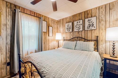 1 dormitorio con 1 cama y paredes de madera en White Pine Perch, en Clayton