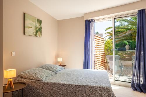 a bedroom with a bed and a large window at Cocon avec piscine et jardin in Marseille