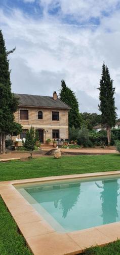 an empty swimming pool in front of a house at Aljubea, tu casa rural en Cordoba in Córdoba