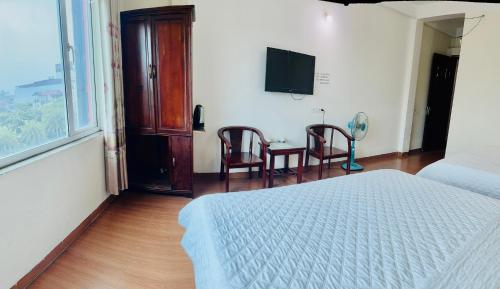 um quarto com uma cama e uma mesa com cadeiras em Van Anh Hotel em Noi Bai