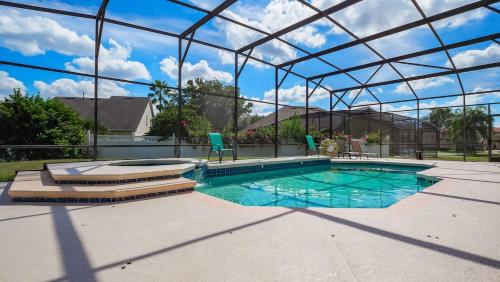 a swimming pool with a glassconservatory and a swimming poolvisor at Tranquil Formosa Gardens Villa in Orlando