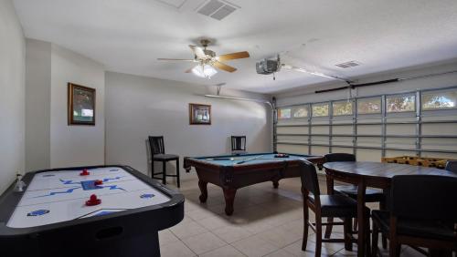 a room with a pool table and some chairs at Tranquil Formosa Gardens Villa in Orlando