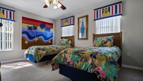 a bedroom with two beds and a painting on the wall at Tranquil Formosa Gardens Villa in Orlando