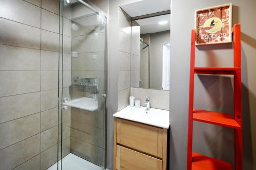 een badkamer met een douche, een wastafel en een spiegel bij Appartement, 2 à 4 pers in Urrugne