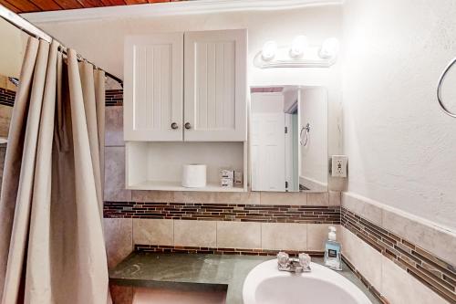 La salle de bains est pourvue d'un lavabo et d'un miroir. dans l'établissement Lake June Resort #10, à Lake Placid