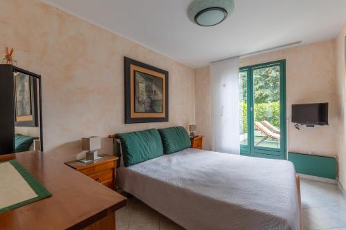 une chambre avec un lit, un bureau et une télévision dans l'établissement Maison Bruno, à Annecy