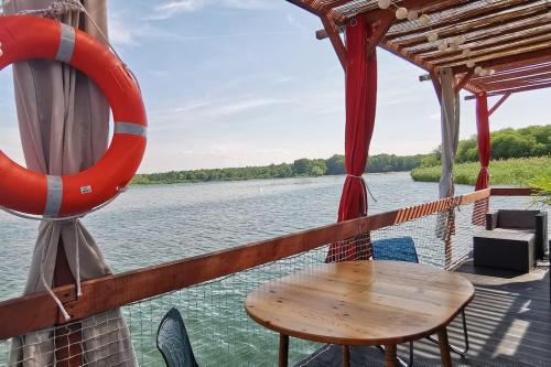 a table on the deck of a boat with a lifesaver at Ma maison sur L'eau - Lac du Der in Giffaumont