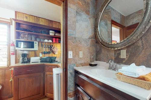 een badkamer met een wastafel en een spiegel bij Latitude Adjustment Gold Standard Certified in Hopkins