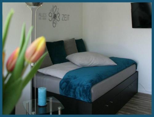 a bedroom with a bed with a pillow and a table at Moderne Wohnung mit Wellnessdusche und Strandkorb in Braunschweig