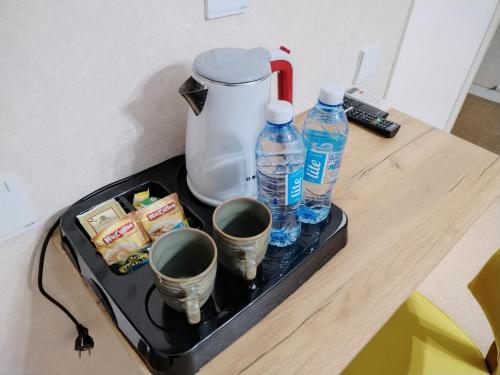 Pera Hotel Baku في باكو: علبة مع زجاجتين من المياه وأكواب على طاولة