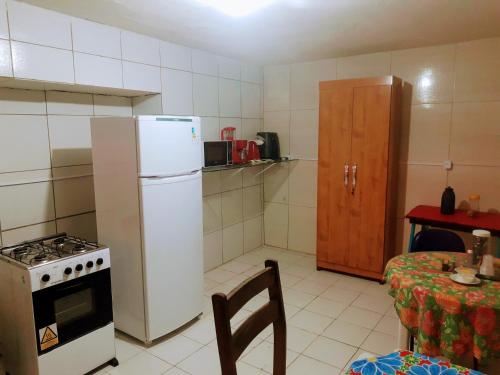 a kitchen with a stove and a refrigerator and a table at Lê'Frevo Pernambucano Hostel in Recife