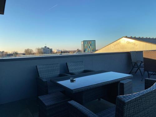 eine Terrasse mit einem Tisch und Stühlen auf dem Balkon in der Unterkunft MARRAM Suitehotel in Münster